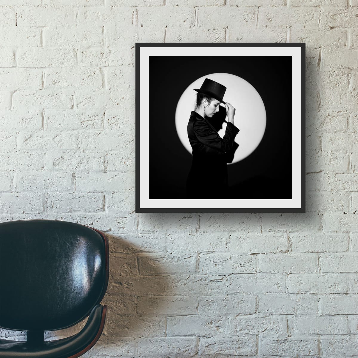 Framed black and white portrait 'In the Spotlight' on a brick wall.