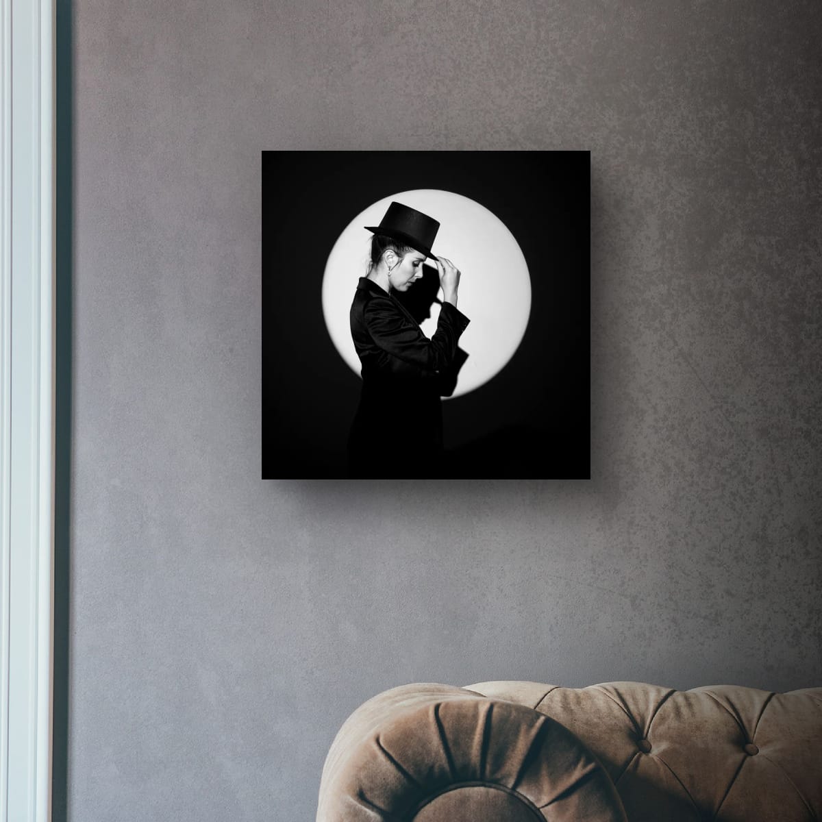 Framed artwork of a person in a top hat 'In the Spotlight' on a gray wall.
