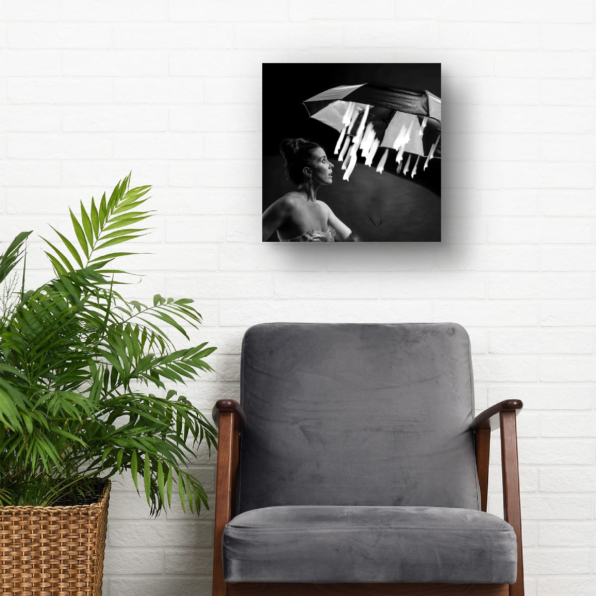 Gray armchair with a plant next to it, featuring a framed black and white photograph Magical starlight on the wall.