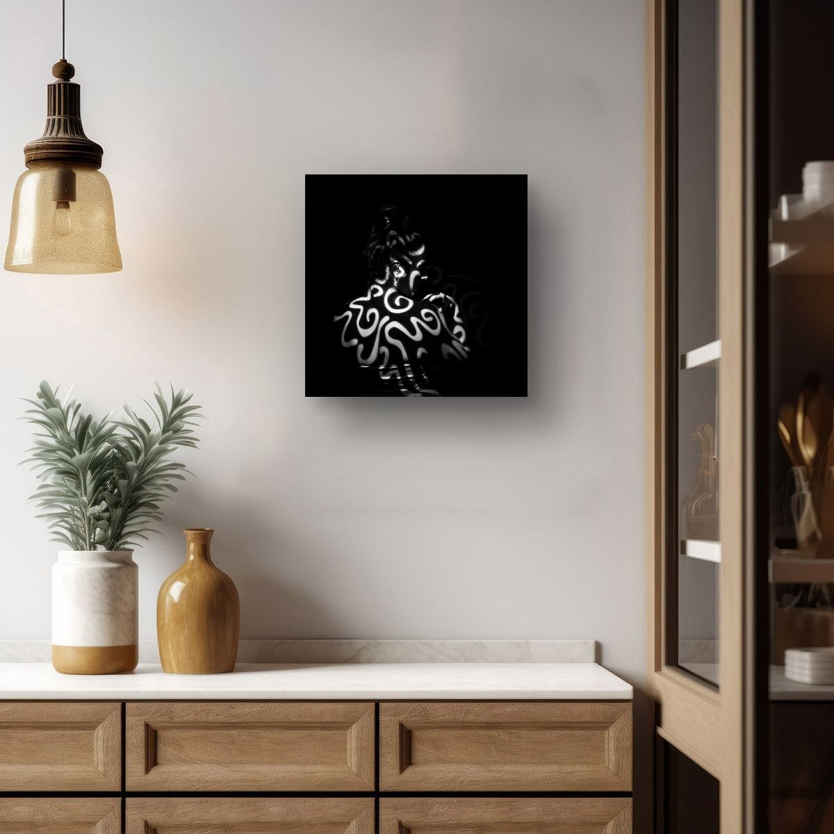 Modern interior with a black and white print Tattooed by light on a wall, wooden cabinet, and decorative items.